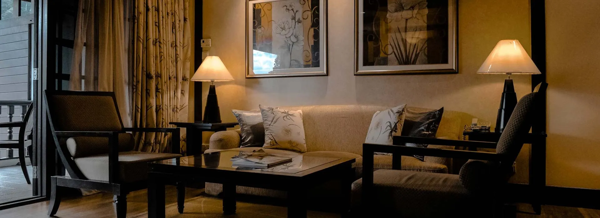 A furnished living room with a sofa, armchairs and table lamps